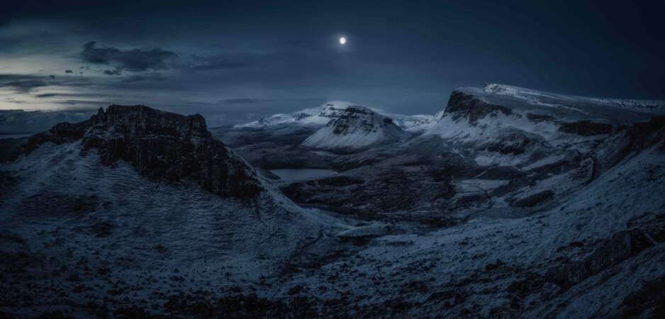 Pleine lune au-dessus du Quiraing, une formation géologique d'origine volcanique, dans la péninsule de l'île de Skye en Écosse.