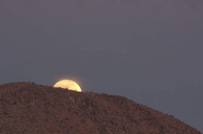La Lune se lève derrière les montagnes de Joshua Tree. 